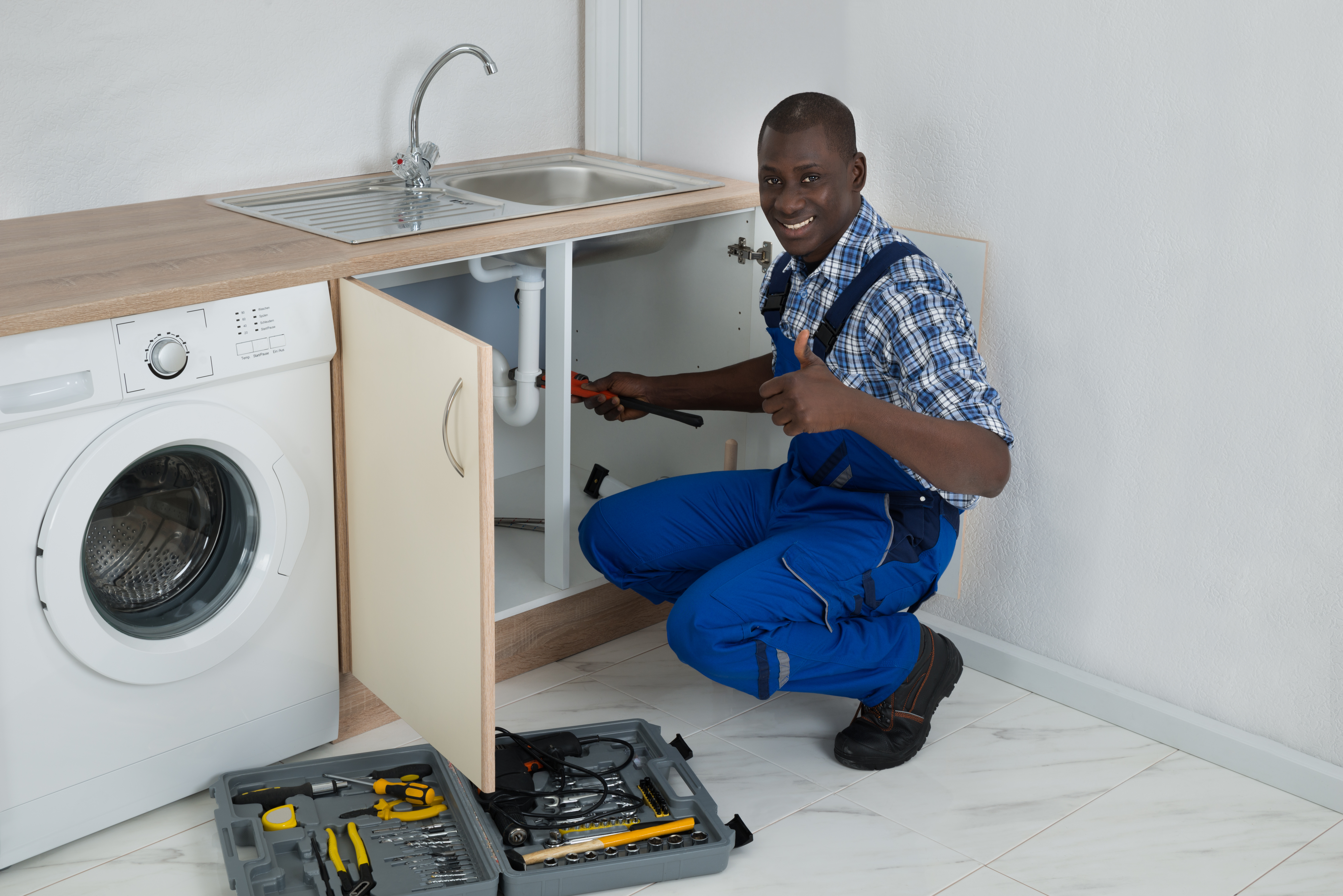 Young Happy African Male Plumber Fixing Sink